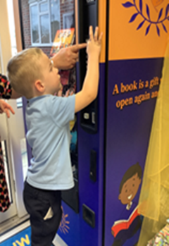 image of young boy using book vending machine