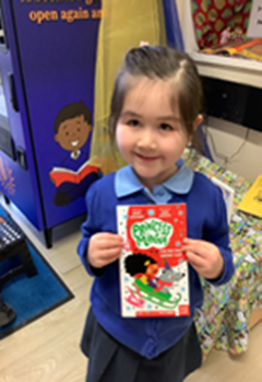 image of pupil holding book