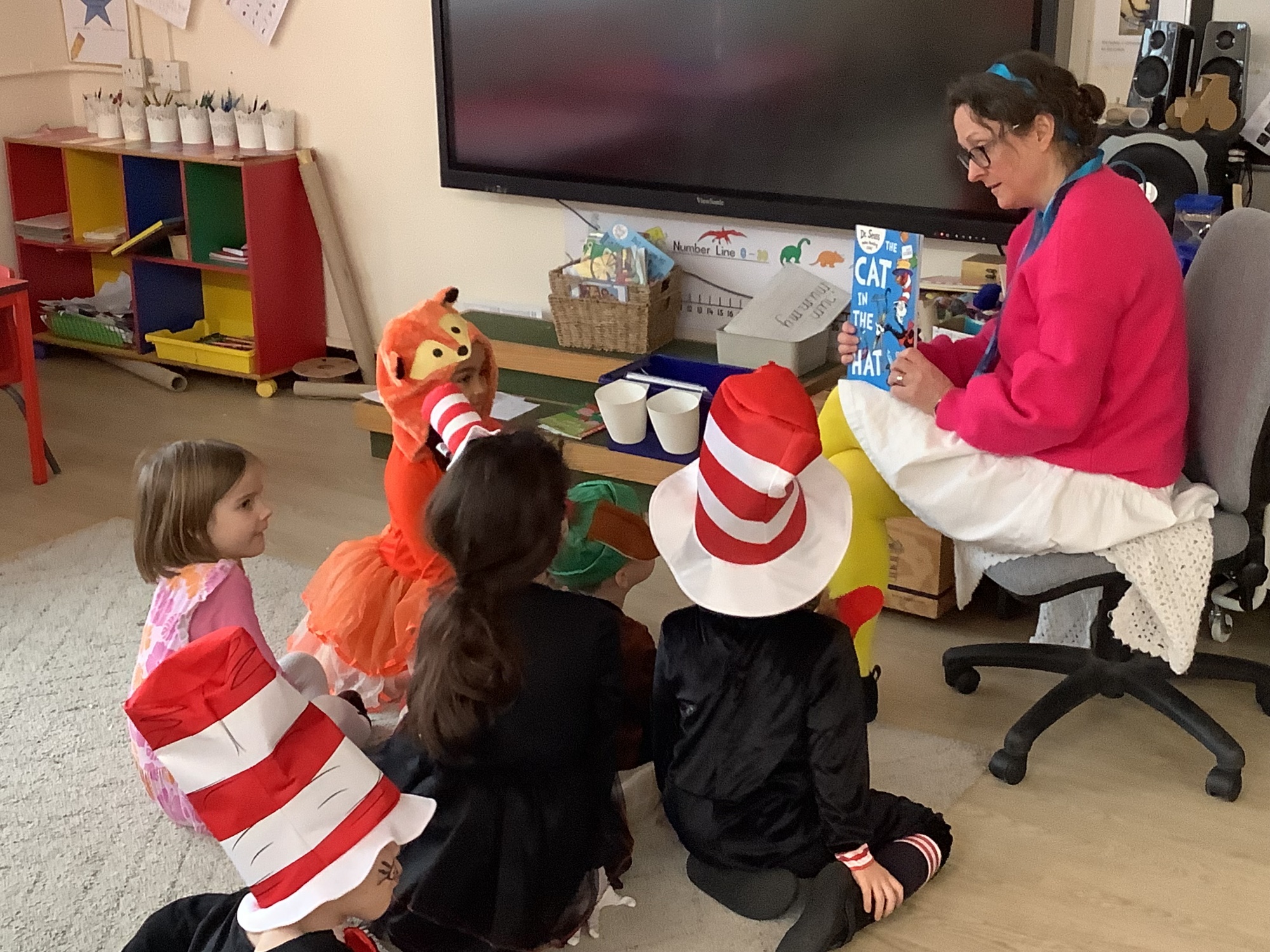 Staff reading to children dressed as characters from Cat in the Hat